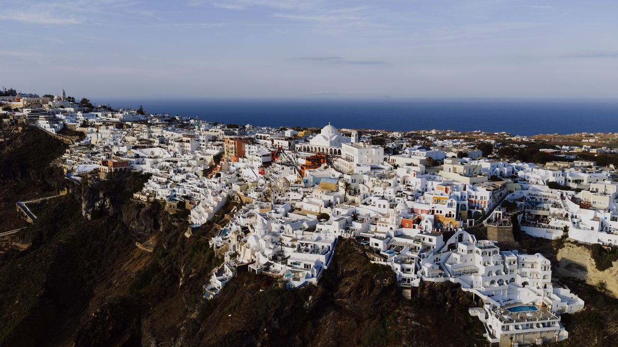 Stunning aerial view of Fira's iconic white architecture against the Aegean Sea.