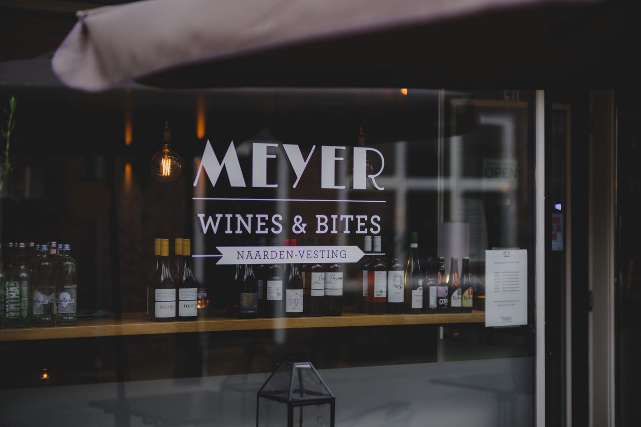 A window display at Meyer Wines & Bites showcasing various bottles in Naarden-Vesting.
